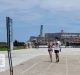 Dos jóvenes caminan por el Malecón de La Habana Vieja