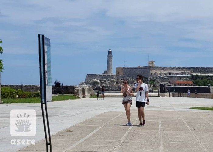 Dos jóvenes caminan por el Malecón de La Habana Vieja