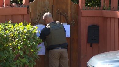 Agente colocando una notificación del proceso en la puerta de la vivienda. (Captura de pantalla © Hatzel Vela-Twitter)