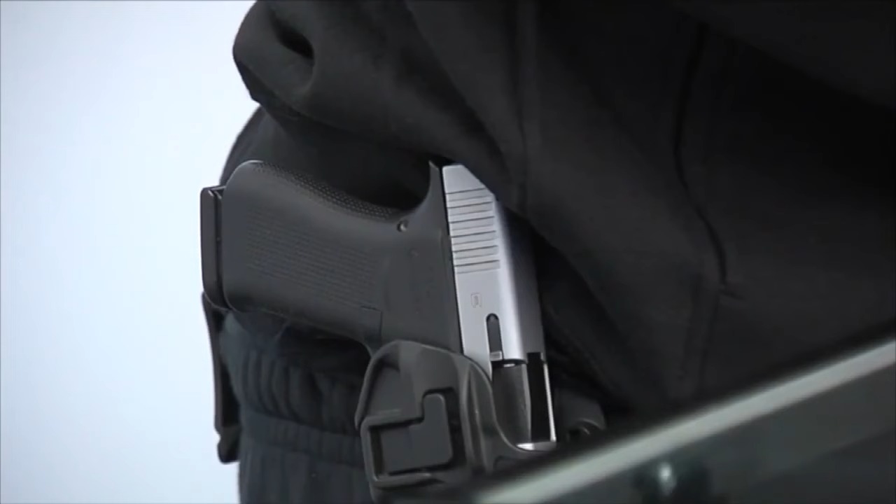 Imagen ilustrativa de un arma siendo portada de forma visible. (Captura de pantalla © WPTVnews-YouTube)