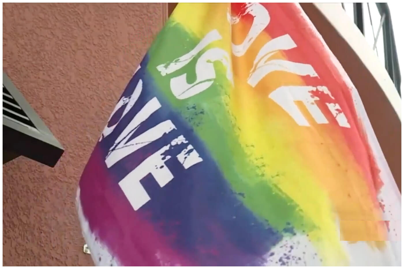 Bandera con la leyenda “Love is Love” (Amor es amor), principal tema de la comunidad LGBT. Imagen de referencia. (Captura de pantalla © WPTV News FL Palm Beach bandera- YouTube)