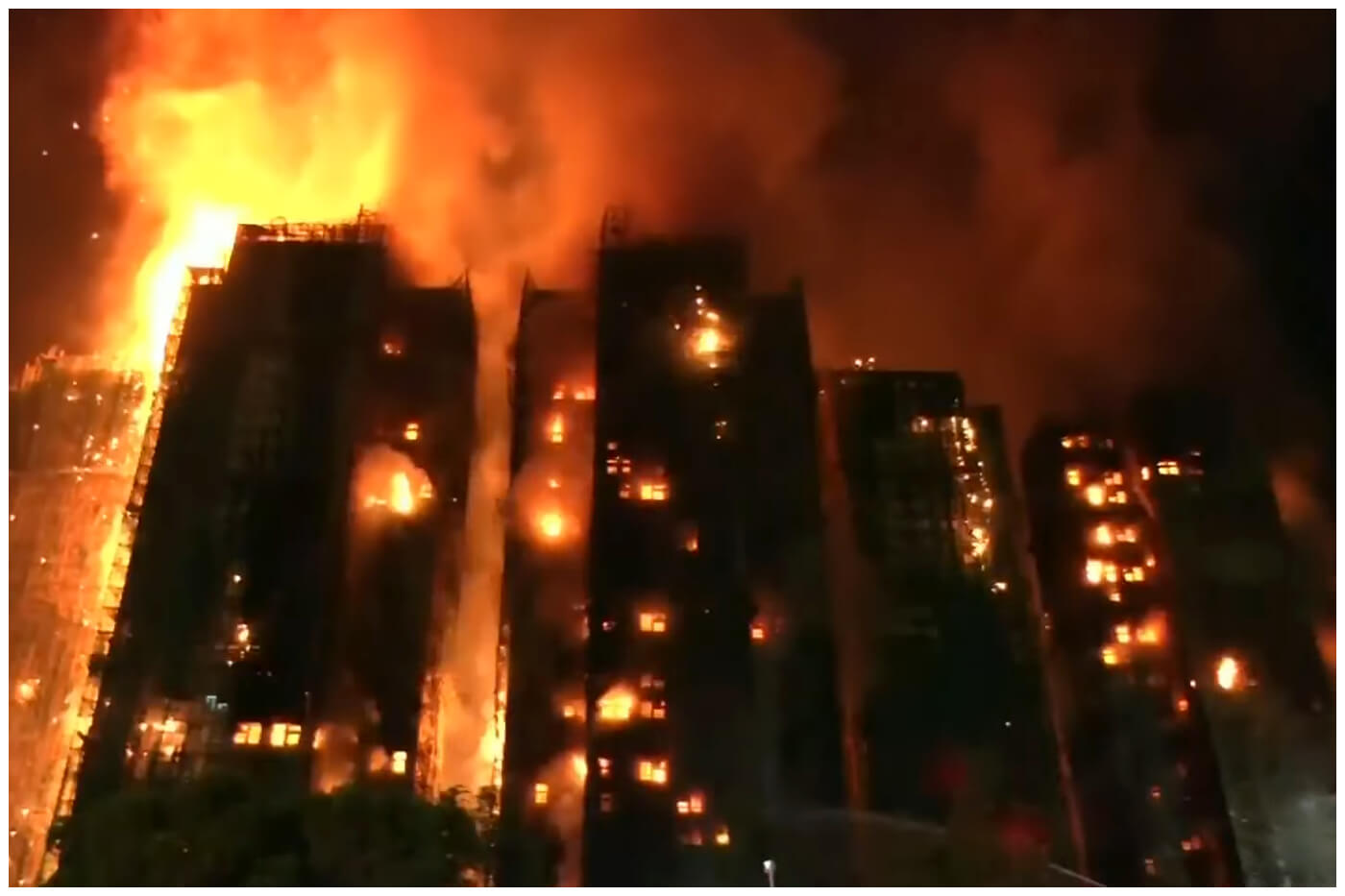 El fuego se extendió por andamios de bambú y lona, afectó siete edificios. (Captura de pantalla © Telemundo 51- YouTube)