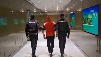 El cubano detenido siendo escoltado por las autoridades panameñas. (Captura de pantalla © LA Prensa Panamá-Twitter)